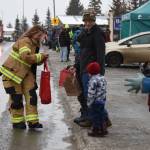 A member of the Homer Volunteer Fire Department hands out candy to young spectators at the Winter Carnival Parade on Saturday, Feb. 14, 2026, in Homer, Alaska. (Delcenia Cosman/Homer News)