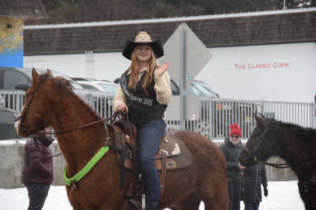 Candace Campbell, the 2025 Ninilchik Rodeo Queen, waves to spectators atop her horse during the Winter Carnival Parade on Saturday, Feb. 14, 2026, in Homer, Alaska. (Delcenia Cosman/Homer News)