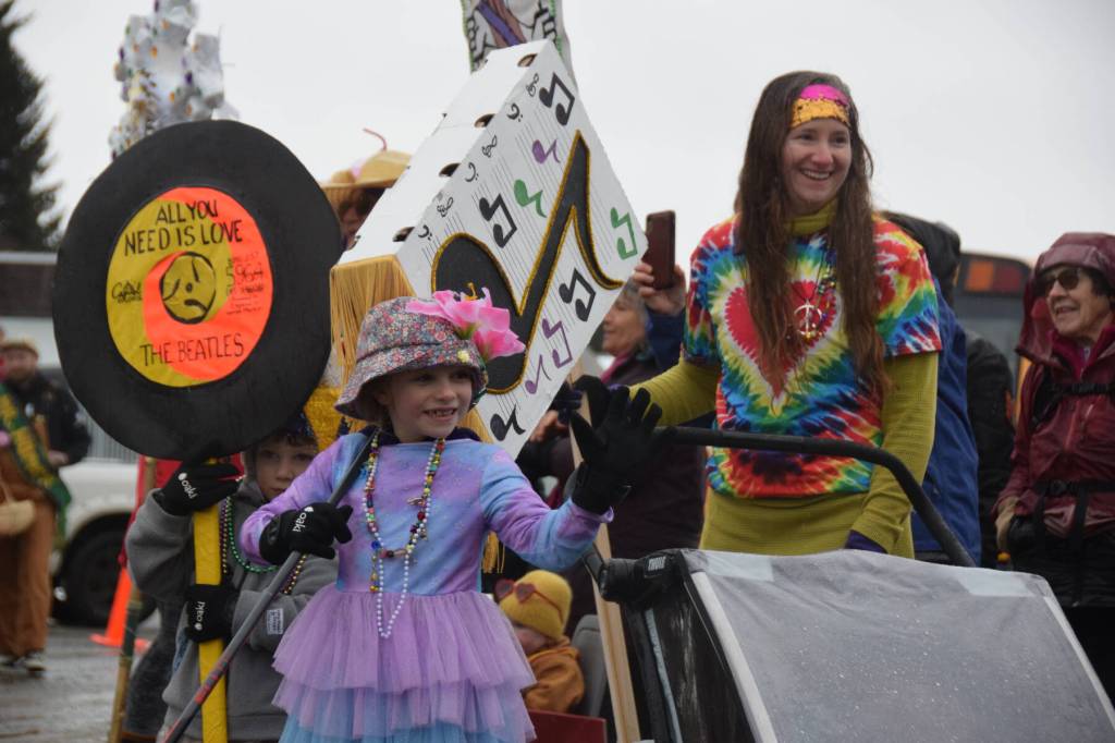 Community members walking with the Krewe of Gambrinus carry props and wave to spectators during the Winter Carnival Parade on Saturday, Feb. 14, 2026, in Homer, Alaska. (Delcenia Cosman/Homer News)