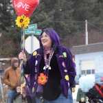 A community member walking with the Krewe of Gambrinus carries a papier mache heart staff during the Winter Carnival Parade on Saturday, Feb. 14, 2026, in Homer, Alaska. (Delcenia Cosman/Homer News)