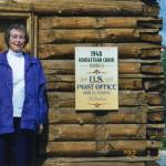In Soldotna in 1992, Maxine Lee stands in front of her old homestead cabin, which became Soldotnas first post office 1949. Lee became the communitys first postmaster. (Photo courtesy of Michael Lee)