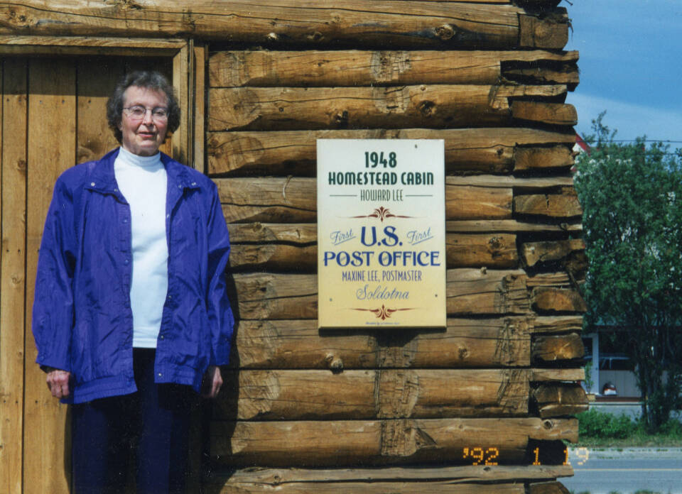 In Soldotna in 1992, Maxine Lee stands in front of her old homestead cabin, which became Soldotnas first post office 1949. Lee became the communitys first postmaster. (Photo courtesy of Michael Lee)