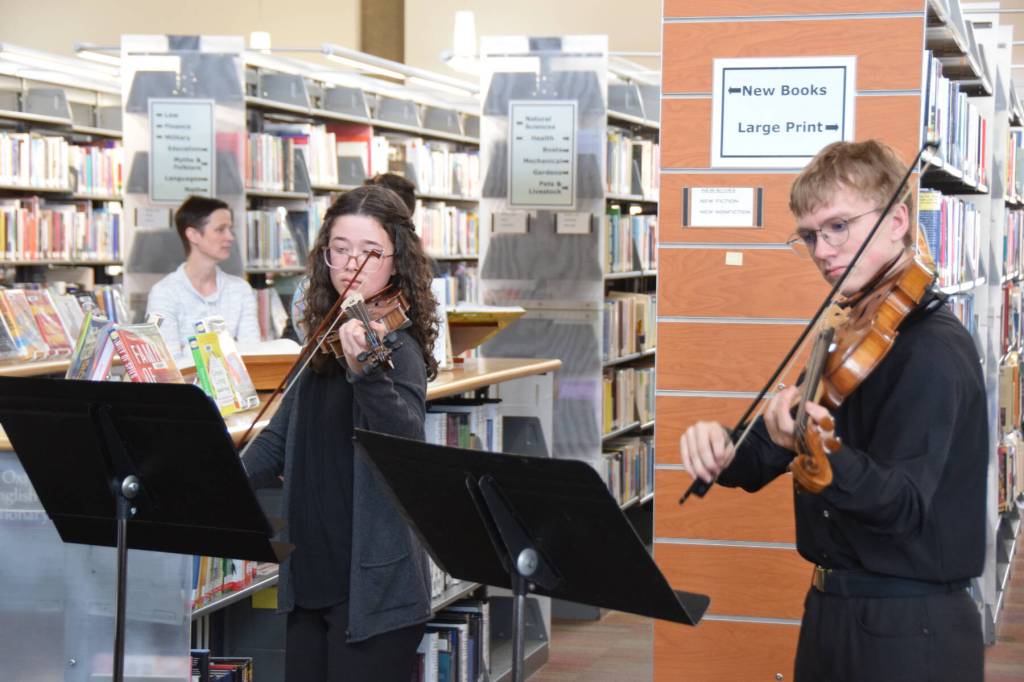Sophie Williams (left) and Daniel Christ (right) perform on stringed instruments during the Celebration of Lifelong Learning at the Homer Public Library on Saturday, March 28, 2026, in Homer, Alaska. (Delcenia Cosman/Homer News)