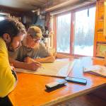 Forest Wagner, left, and Charlie Campbell of Tanana confer over a map at Campbells house in Tanana on March 29, 2026. Photo courtesy Ned Rozell