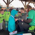 Program mentors hand out medals to Girls on the Run and Let Me Run youth participants after a celebratory 5K race on Sunday, May 10, 2026, on the Homer Spit Trail in Homer, Alaska. Photo courtesy Marcee Gray