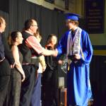 Homer High School Class of 2026 valedictorian Lukas Renner (center) shakes hands with Kenai Peninsula Borough School District representatives as he receives his diploma in a commencement ceremony on Monday, May 18<ins>,</ins> <ins>2026</ins>, in the Homer High School Alice Witte Gymnasium<ins> in Homer, </ins><ins>Alaska</ins>. (Delcenia Cosman/Homer News)