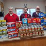 Homer Elks Lodge Exalted Ruler John Mink (left), Inner Guard Michael Swoboda, Trustee Matthew Hockema, and Leading Knight Jill Hockema with some of the items donated to the Homer Food Pantry.