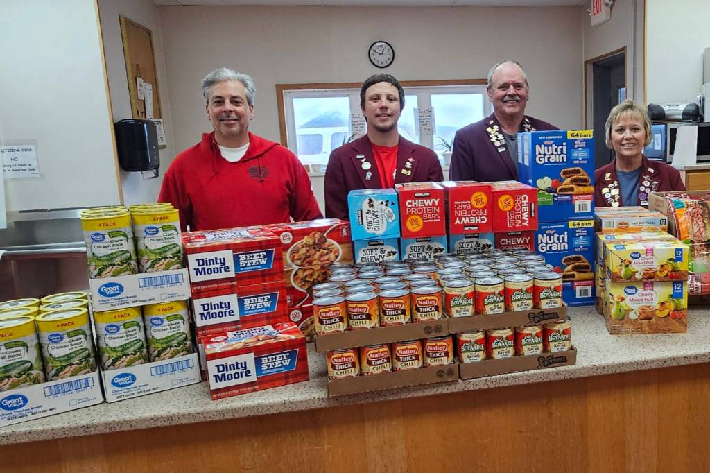 Homer Elks Lodge Exalted Ruler John Mink (left), Inner Guard Michael Swoboda, Trustee Matthew Hockema, and Leading Knight Jill Hockema with some of the items donated to the Homer Food Pantry.